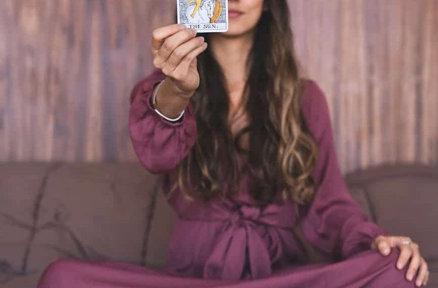 woman in purple dress holding a tarot card