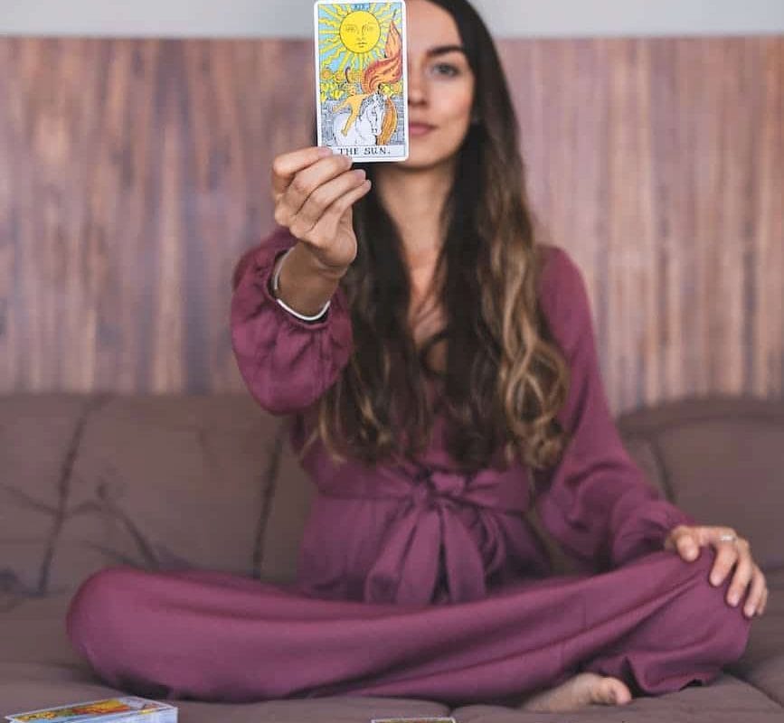 woman in purple dress holding a tarot card