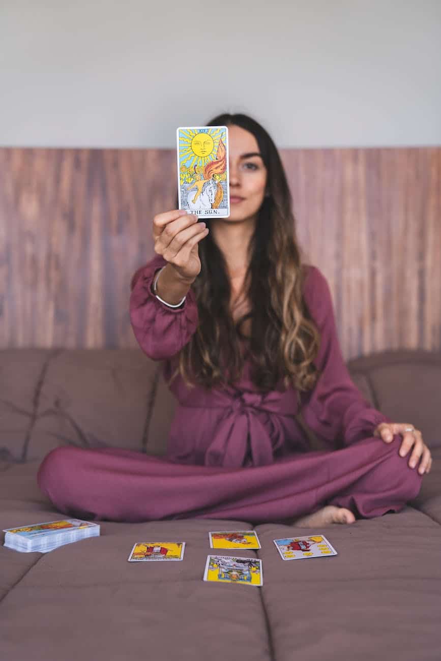 woman in purple dress holding a tarot card