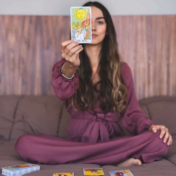 woman in purple dress holding a tarot card